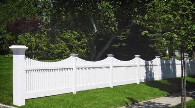 White vinyl fence installation separating a yard from the sidewalk