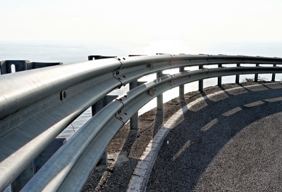 Metal beam guardrail installation on the edge of a curved road