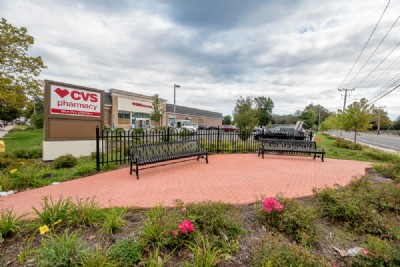 Ornamental metal fencing near benches outside of a pharmacy