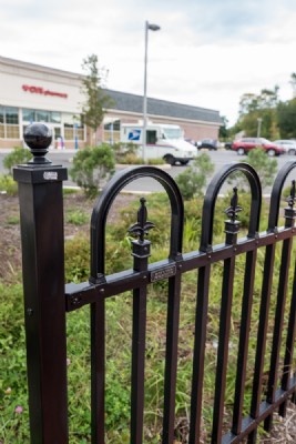 Close-up photo of black ornamental metal fencing security gate installed outside of a pharmacy