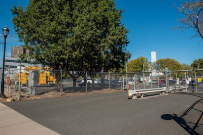 Chain link fence installation ct in parking lot near leafy tree