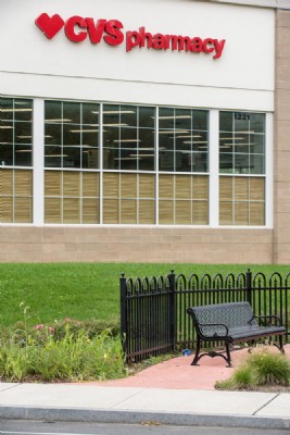 Ornamental metal fencing near bench outside of a pharmacy.