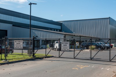 Security fence installation with a sign attached that reads "no public entry" outside of a building