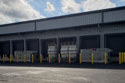 Yellow security bollards in driveway protecting air conditioning vents