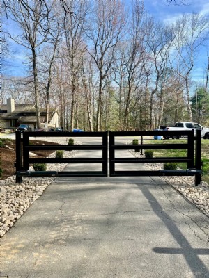 Automated residential gate installed with keypad for entry and free exit.