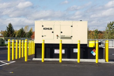 Yellow security bollard posts surrounding a generator