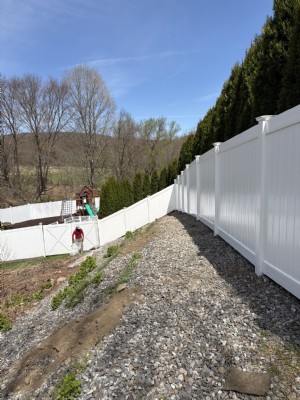 Residential vinyl fence installed down a slope.