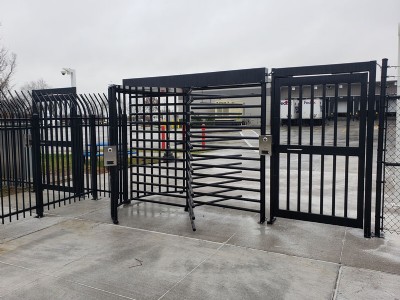 Turnstile security gate with loading dock in the background