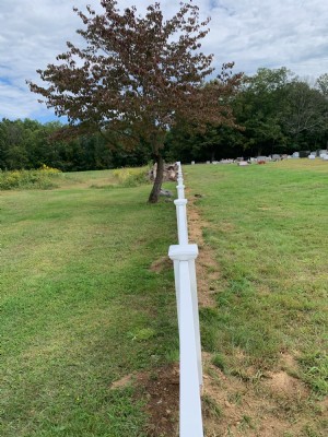 White vinyl fencing installation in yard