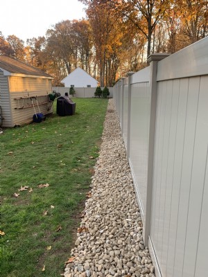 White vinyl fencing installation in backyard